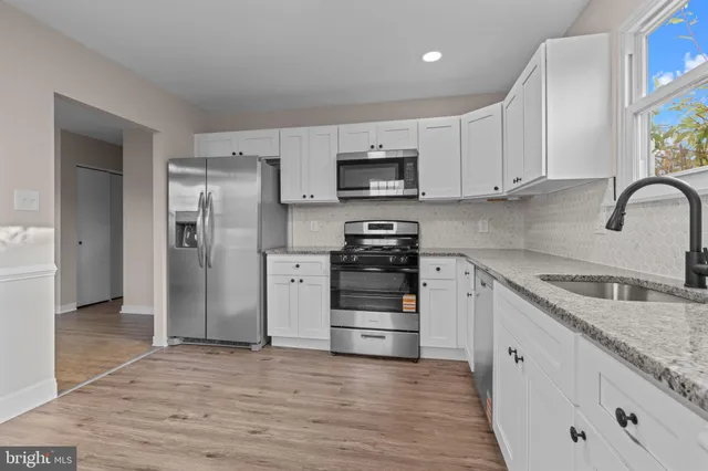 a kitchen with stainless steel appliances granite countertop a refrigerator and a stove top oven