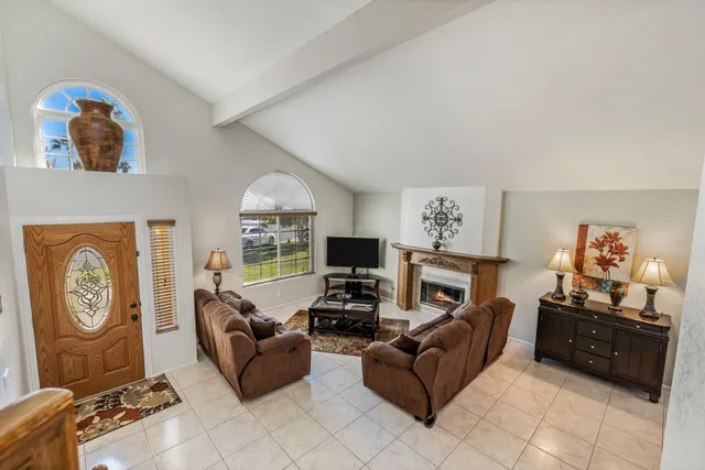 a living room with furniture a fireplace and a flat screen tv