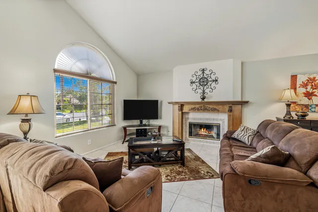 a living room with furniture a flat screen tv and a fireplace
