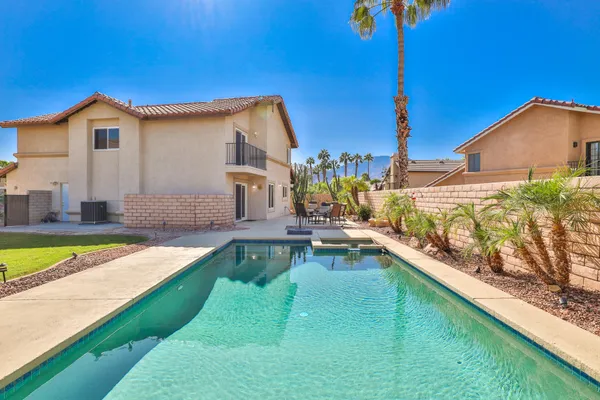 a view of a house with pool and sitting area