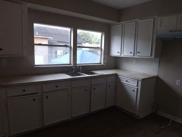a kitchen with sink window and cabinets