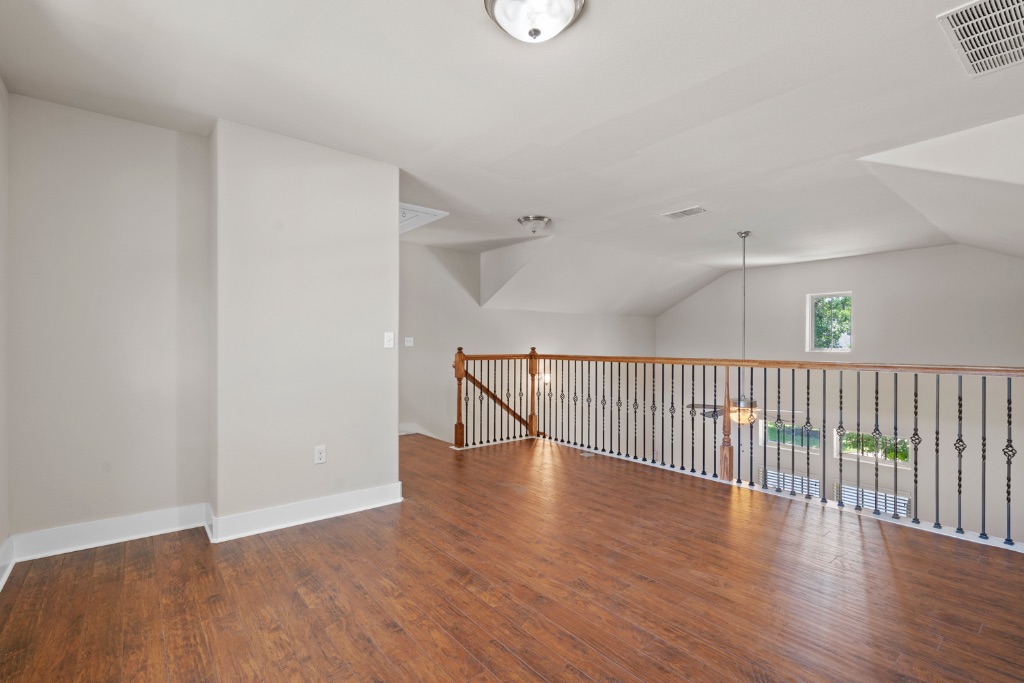 11229 Avery Station Loop, Unit 36 Austin, TX 78717 - Photo 21 of 37 Empty room with dark wood-type flooring and vaulted ceiling