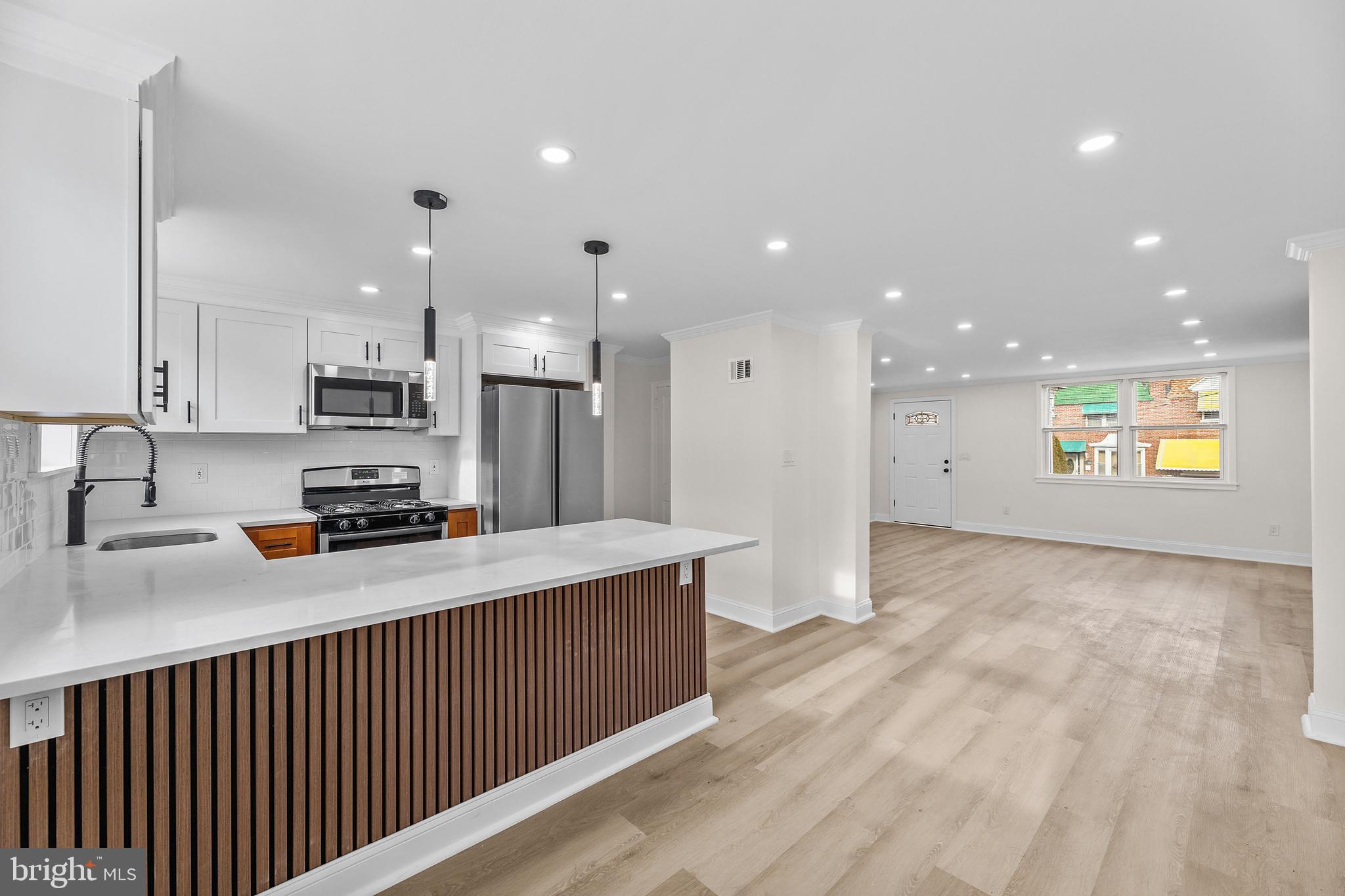 7920 Provident Street Philadelphia, PA 19150 - Photo 1 of 32 a kitchen with stainless steel appliances granite countertop a refrigerator a sink dishwasher and a stove with wooden floors