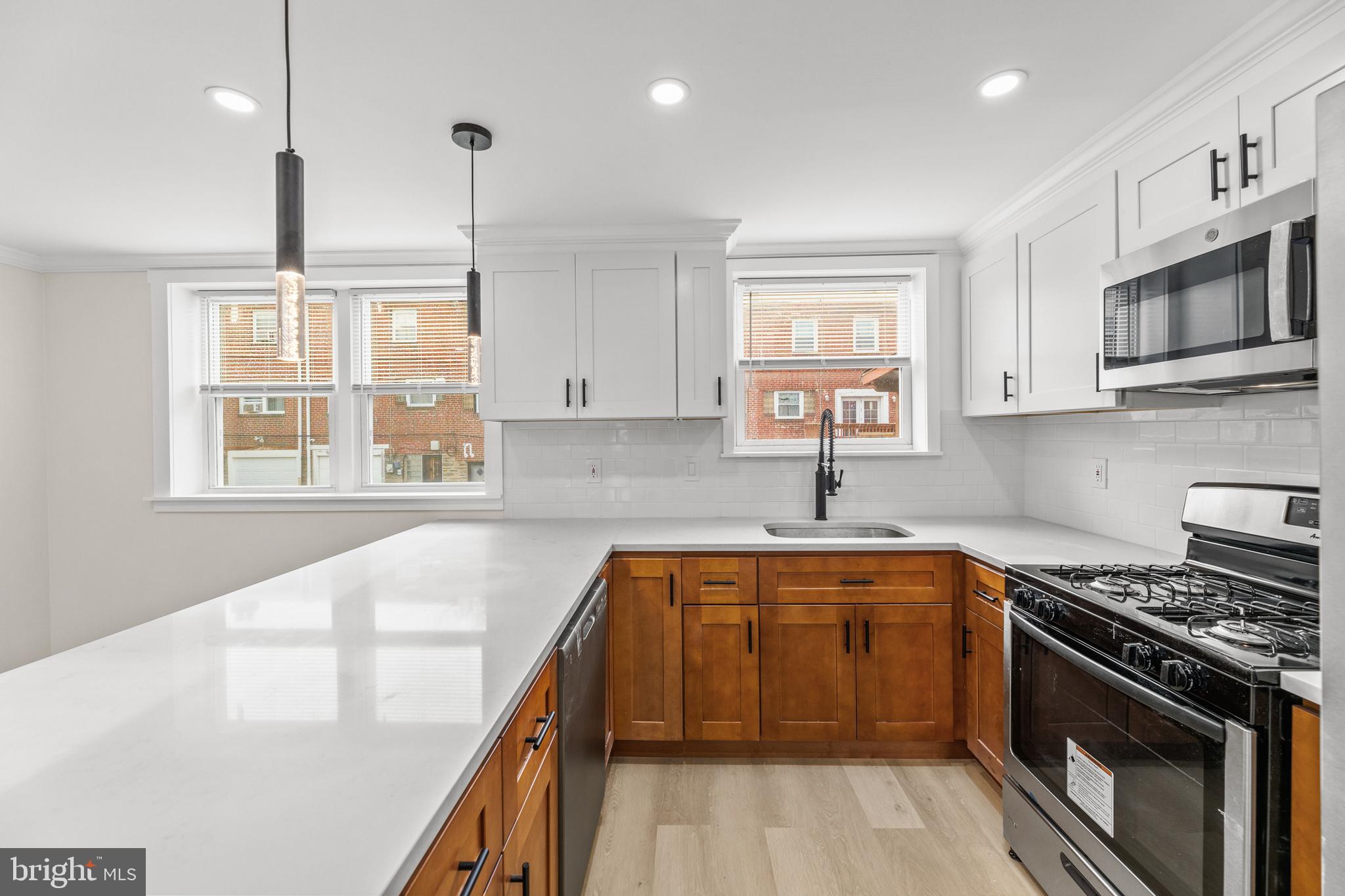 7920 Provident Street Philadelphia, PA 19150 - Photo 15 of 32 a kitchen with stainless steel appliances a stove sink microwave and cabinets