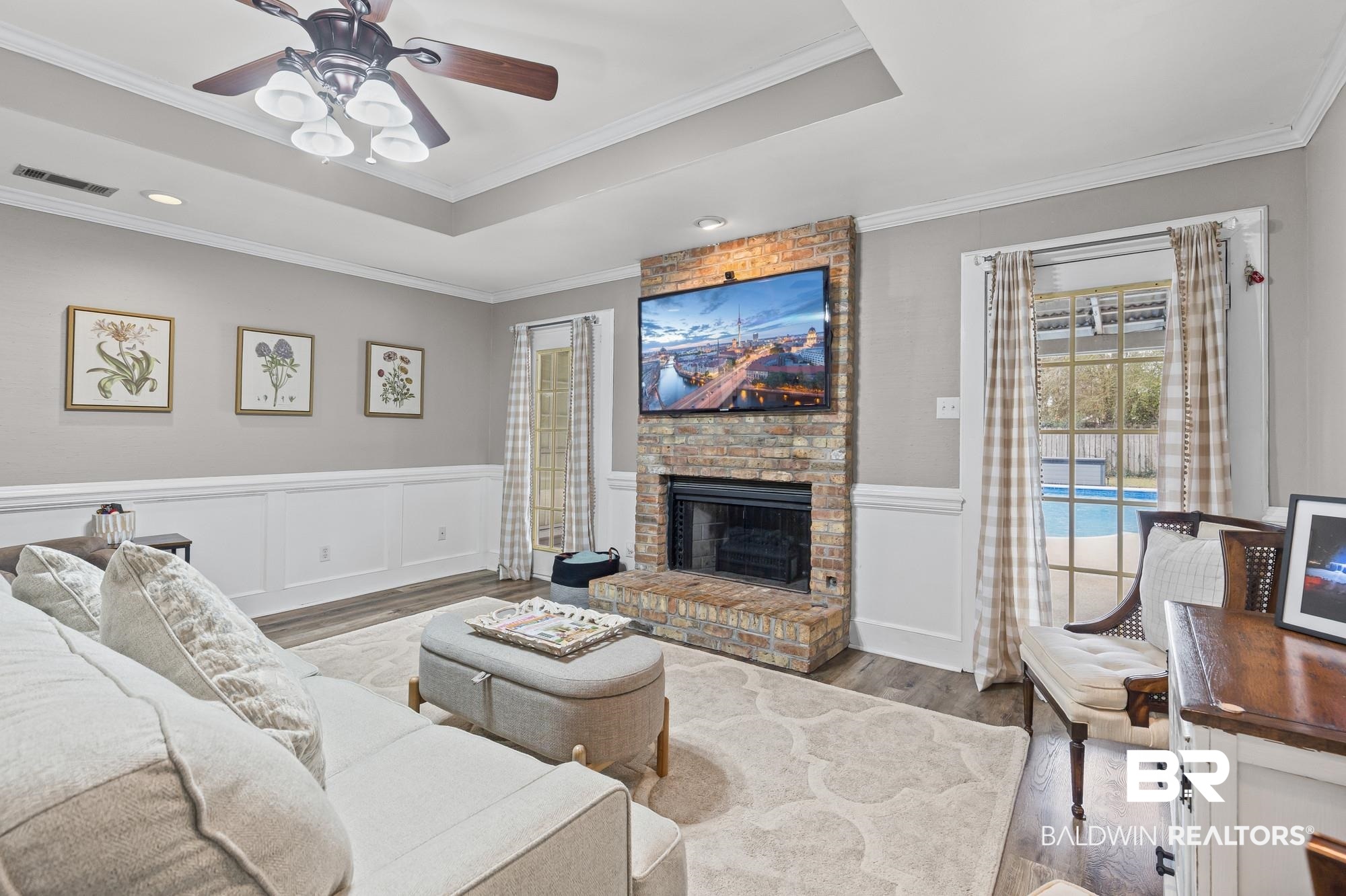 6609 Blakeley Court Mobile, AL 36695 - Photo 11 of 28 Living room with wainscoting, a decorative wall, wood finished floors, a fireplace, and ornamental molding