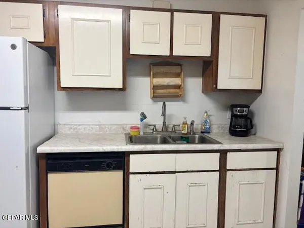a kitchen with appliances a sink and cabinets