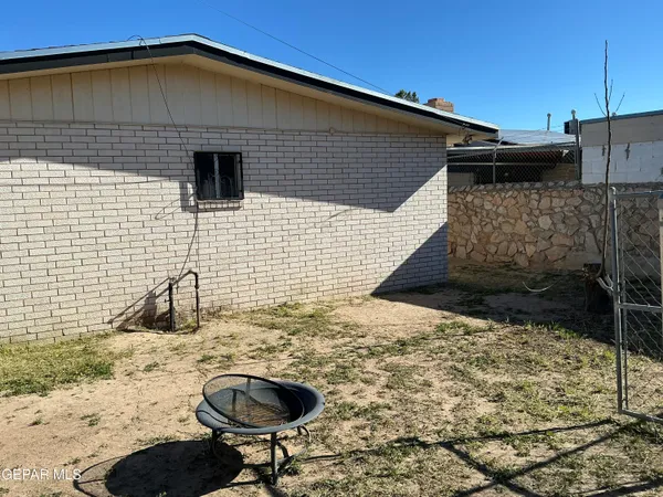 a backyard of a house with table and chairs