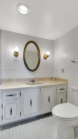 a bathroom with a toilet a sink and mirror