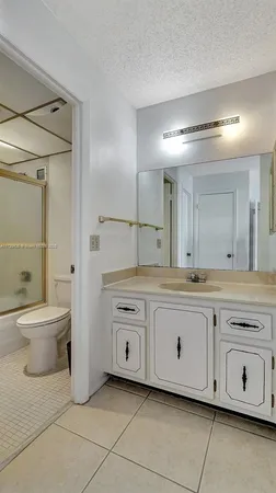 a spacious bathroom with a granite countertop sink a toilet and a bathtub
