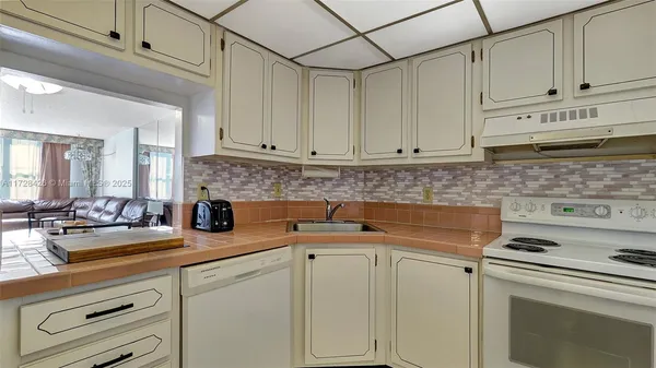 a kitchen with white cabinets and white appliances