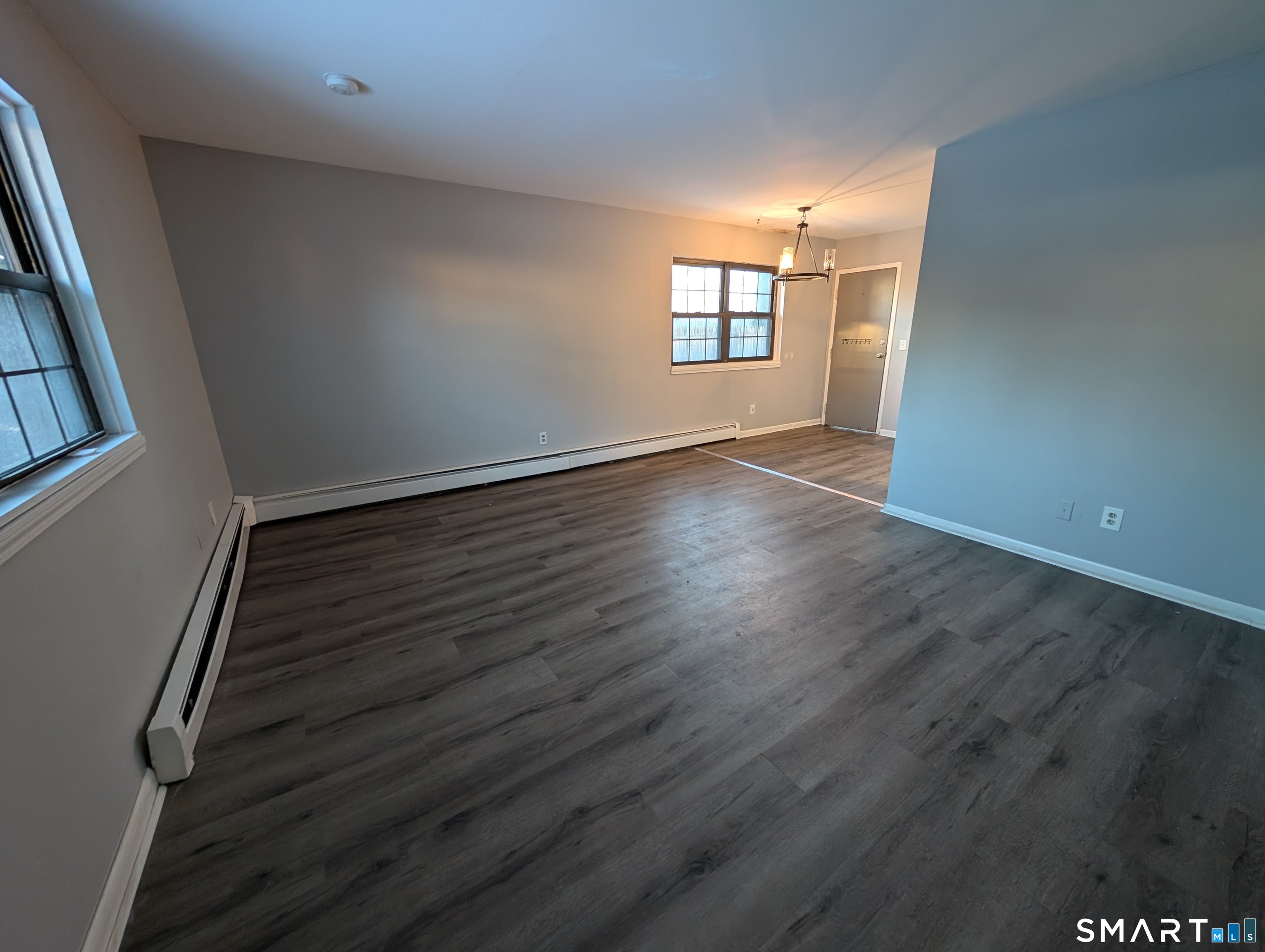 21 Enid Street, Unit A Bridgeport, CT 06606 - Photo 4 of 10 an empty room with wooden floor and windows