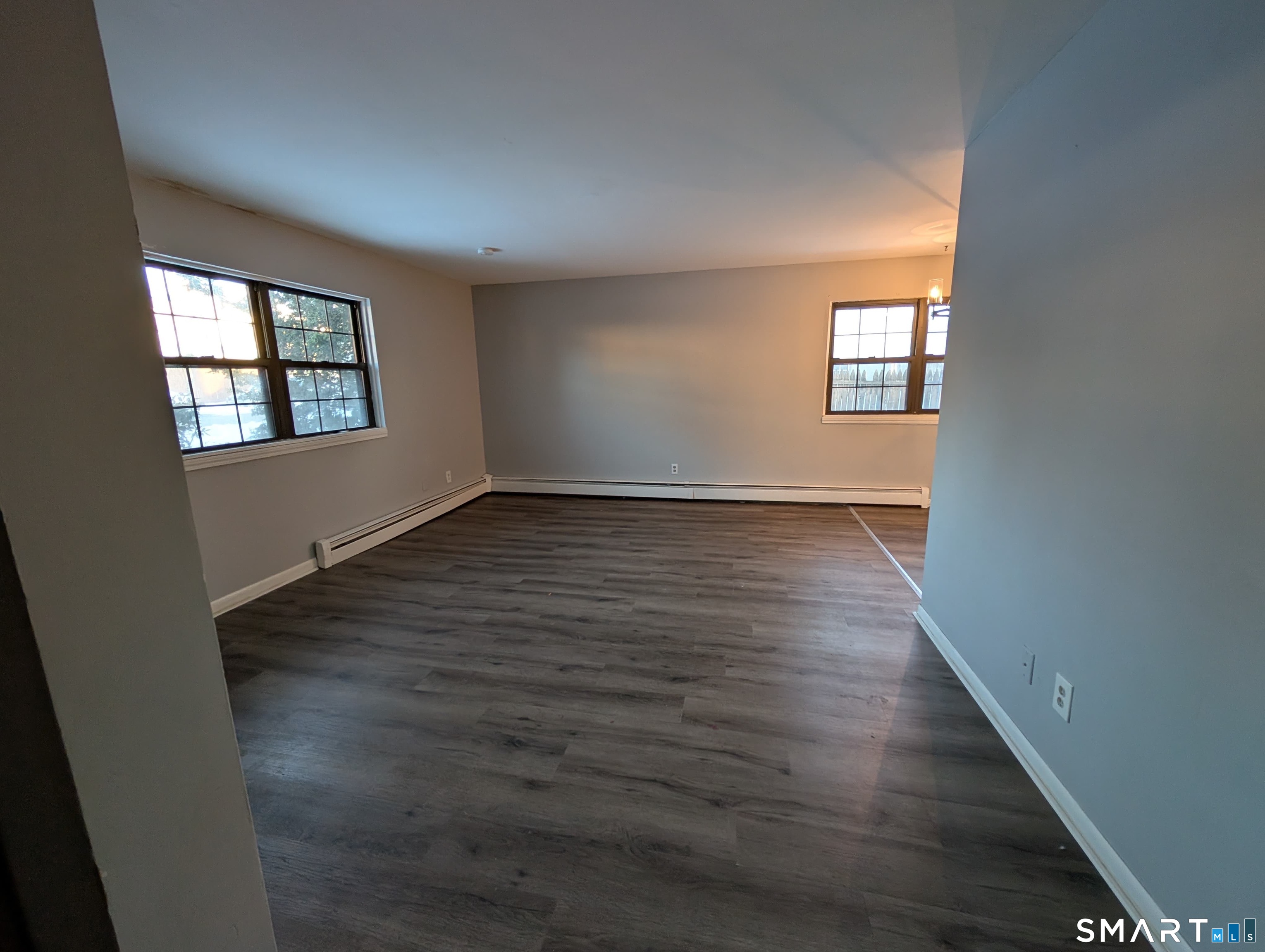 21 Enid Street, Unit A Bridgeport, CT 06606 - Photo 5 of 10 an empty room with wooden floor and windows