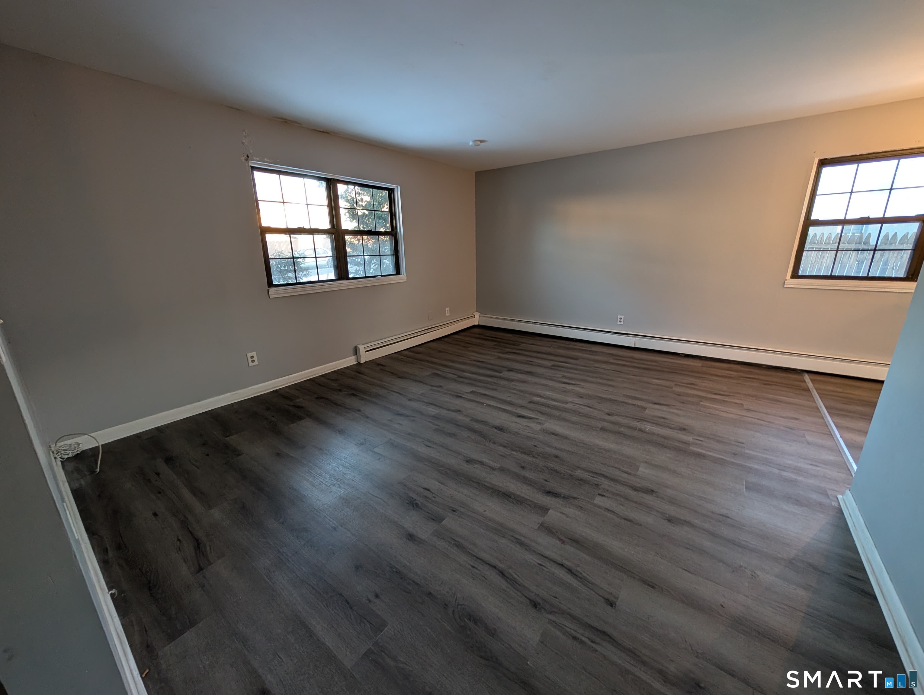 21 Enid Street, Unit A Bridgeport, CT 06606 - Photo 9 of 10 a view of an empty room with wooden floor and a window