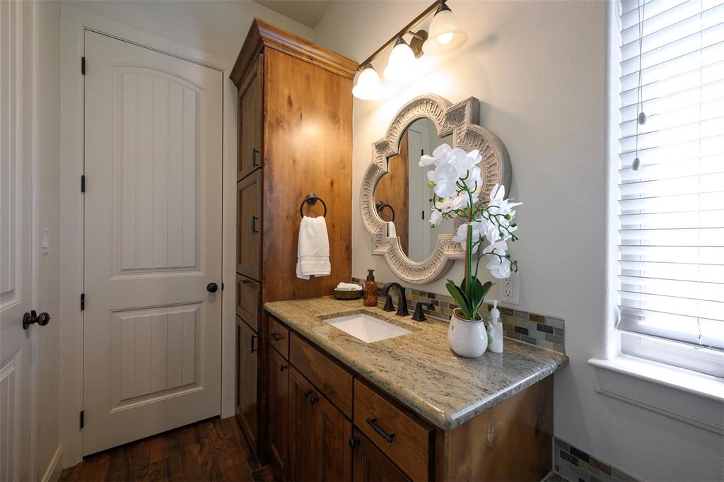1003 Buckner Road Lipan, TX 76462 - Photo 19 of 31 a bathroom with a granite countertop sink a mirror and a shower
