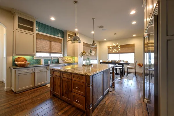 a kitchen with stainless steel appliances granite countertop a sink a stove and cabinets