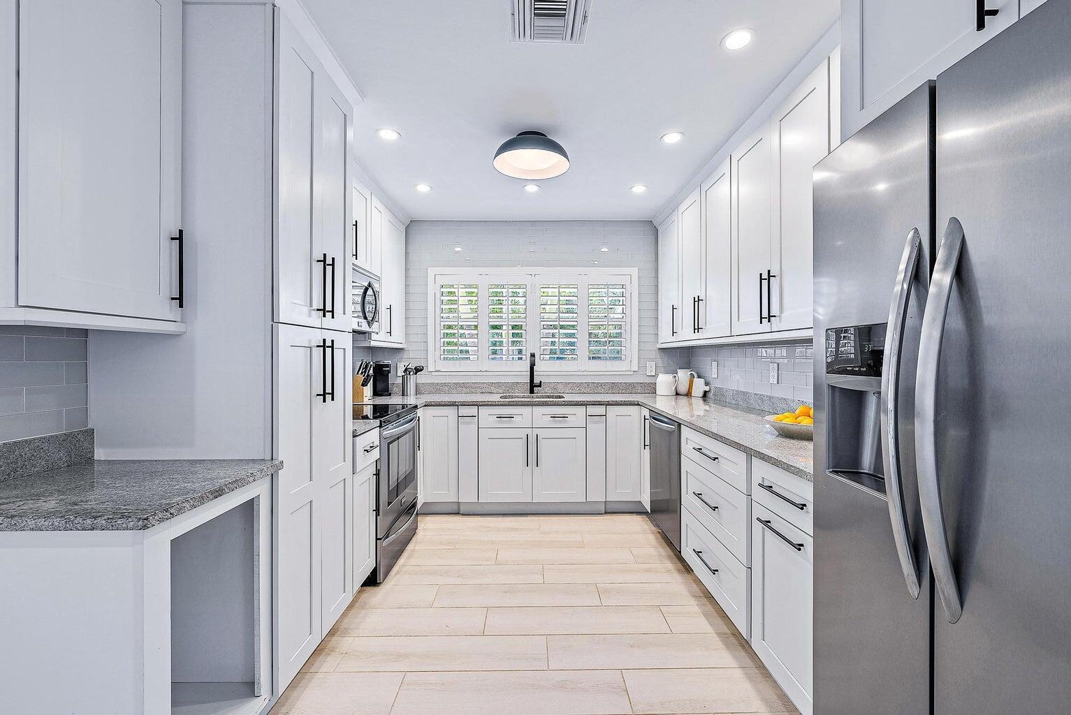 215 Cortez Road West Palm Beach, FL 33405 - Photo 5 of 17 a kitchen with stainless steel appliances granite countertop a refrigerator and a sink