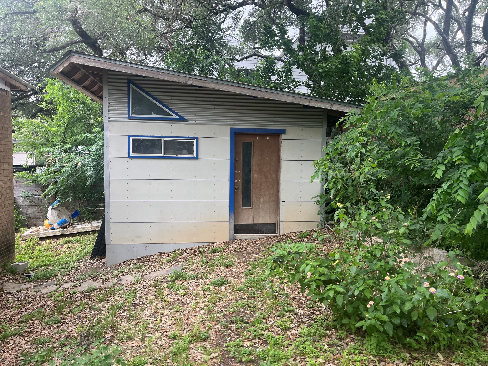 1607 Lightsey Road, Unit A Austin, TX 78704 - Photo 16 of 17 Shed structure with a sloped roofline, featuring a triangular accent window and a horizontal rectangular window