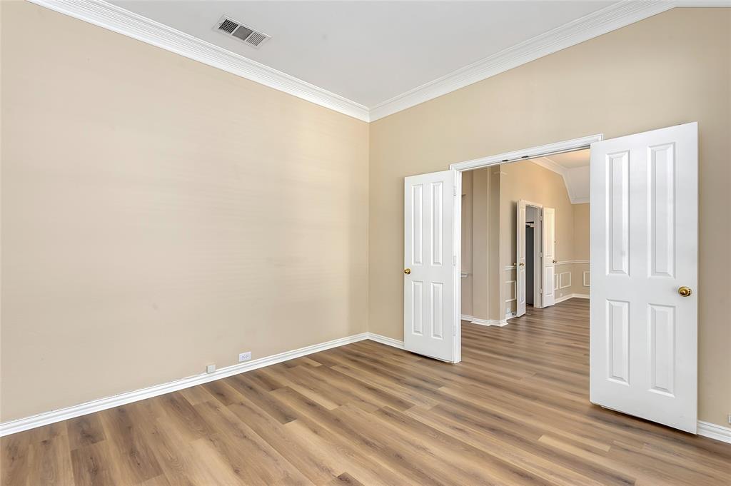 1404 Ranch Hill Drive Irving, TX 75063 - Photo 7 of 31 Neutral-toned room featuring wood-finish flooring and white crown molding