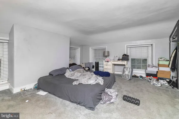 a bed sitting in a bedroom next to a window with pc on the table
