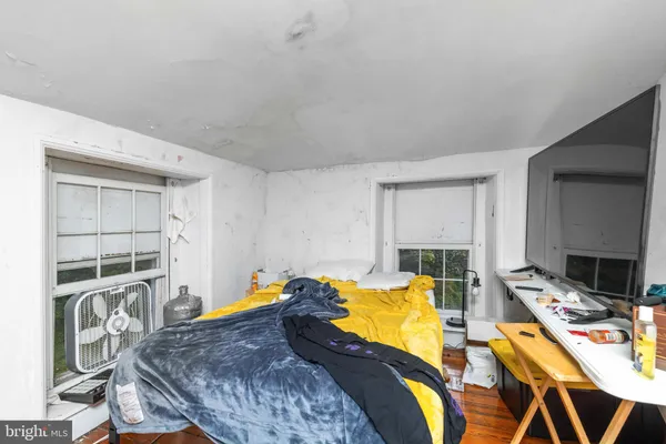 a living room with furniture a flat screen tv and a bed