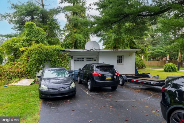 a view of a house with a big yard and large trees