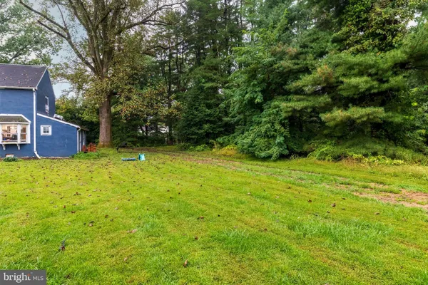 a view of a house with a yard and tree s