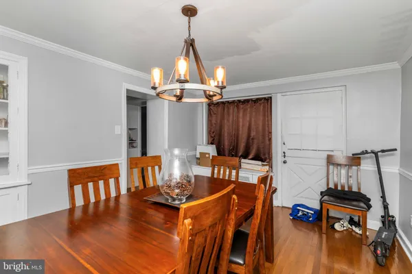 a living room with furniture a dining table and a chandelier