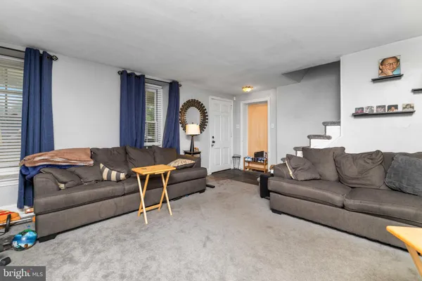 a living room with furniture a flat screen tv and a book shelf