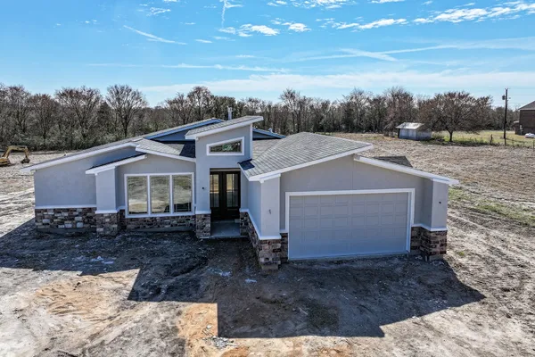 a view of a grey house with a yard