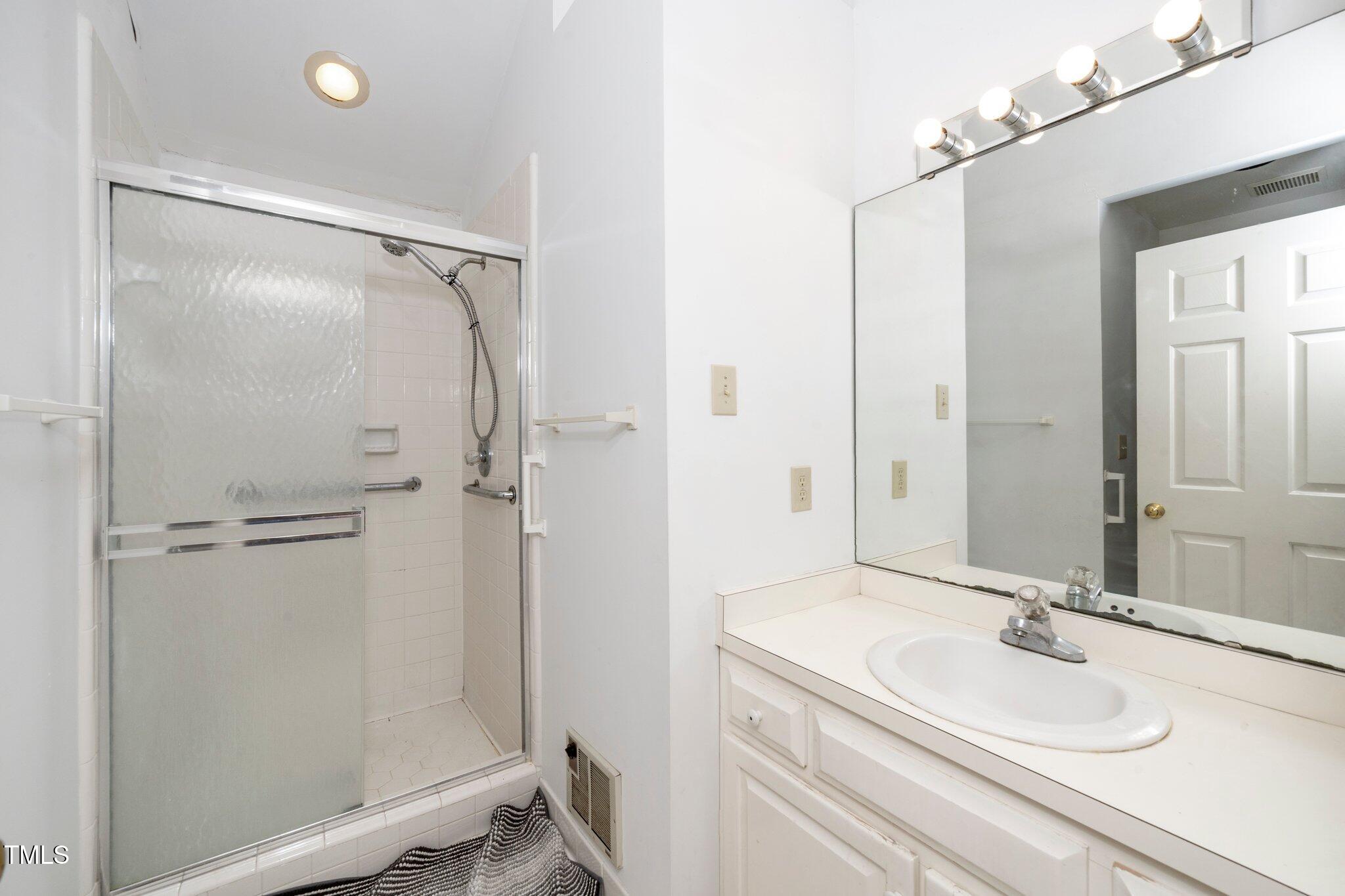 6312 New Market Way Raleigh, NC 27615 - Photo 15 of 31 a bathroom with a sink and a mirror