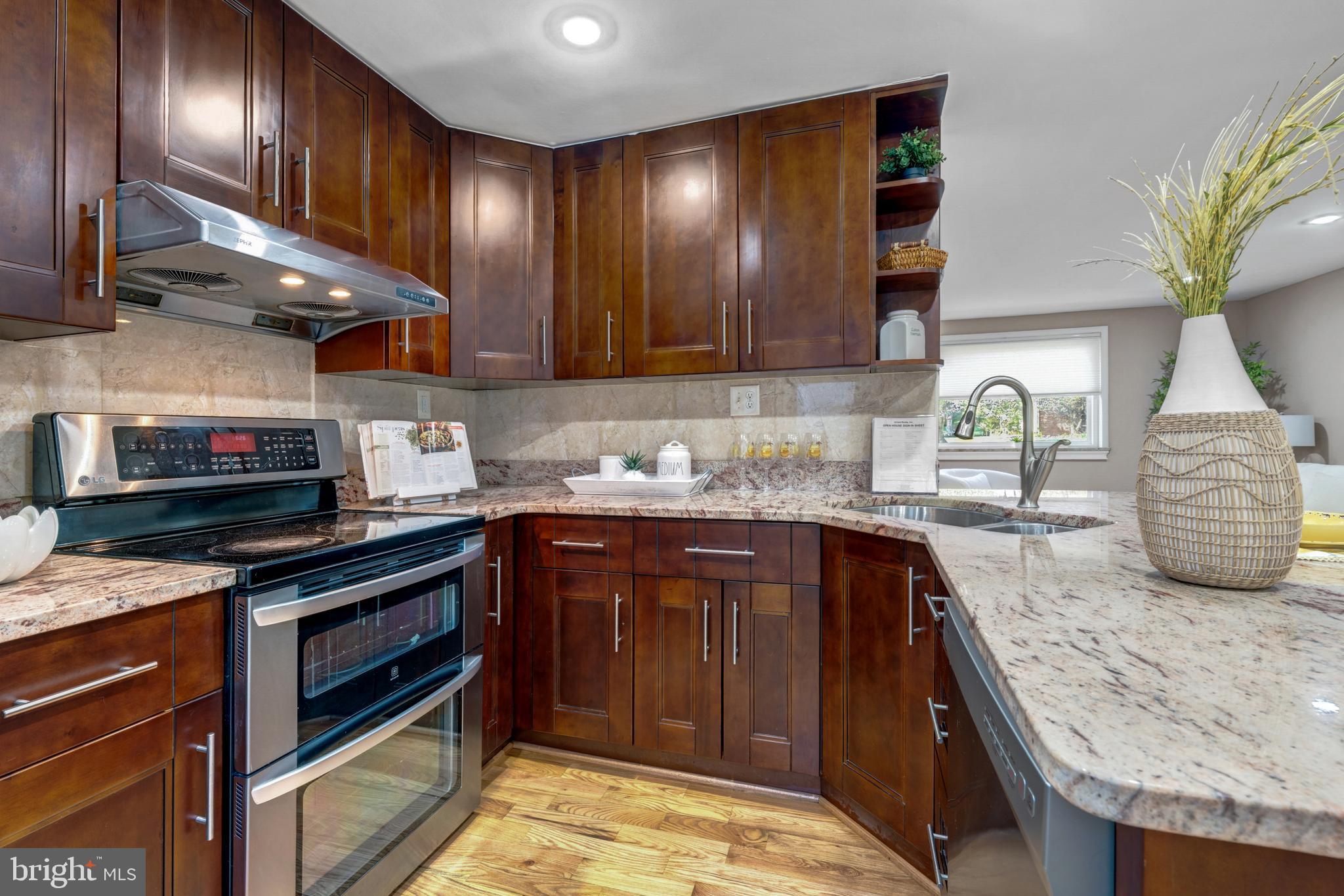 12772 Bradwell Road Herndon, VA 20171 - Photo 13 of 43 a kitchen with stainless steel appliances granite countertop wooden cabinets a stove top oven a sink and dishwasher