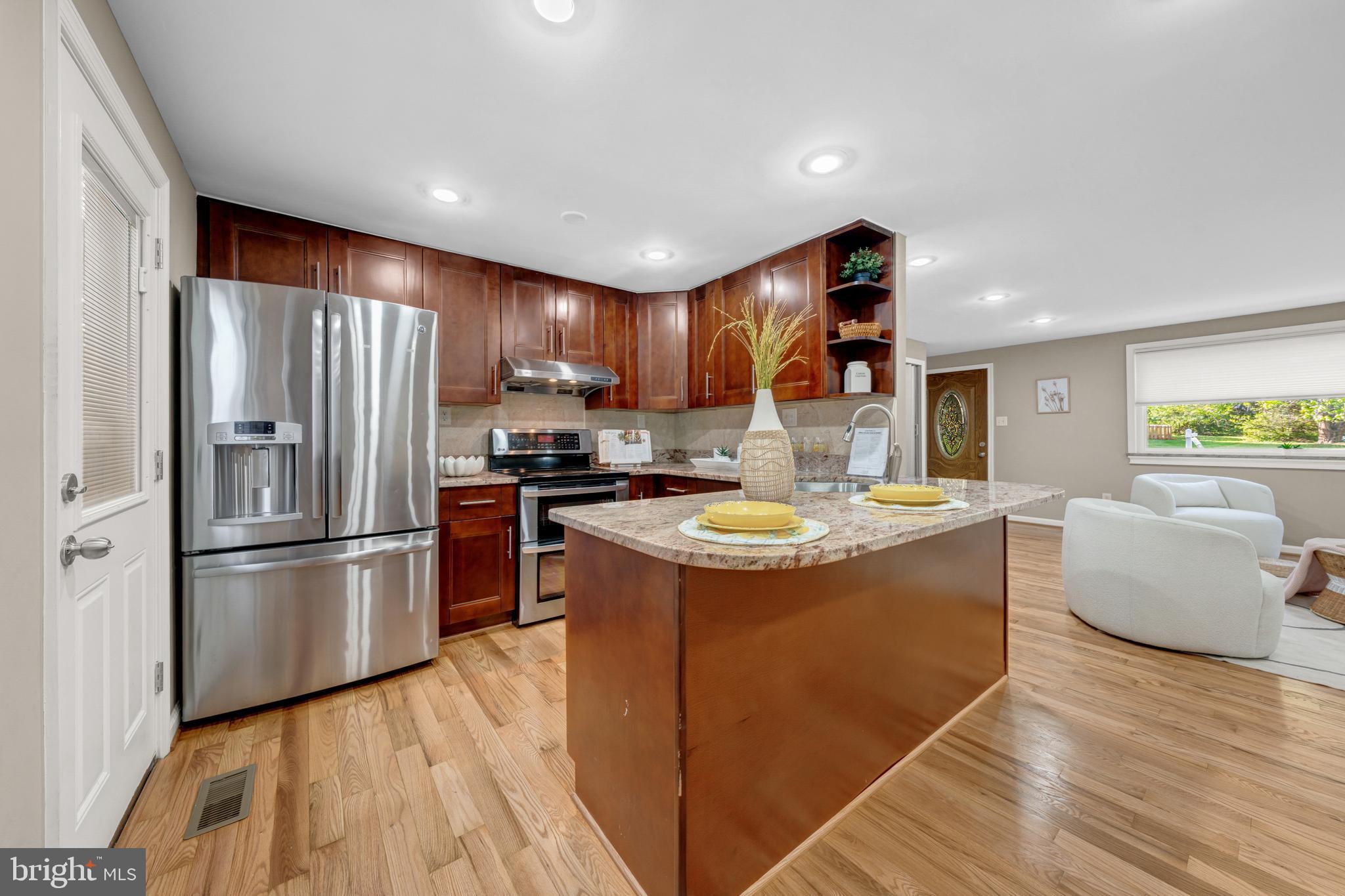 12772 Bradwell Road Herndon, VA 20171 - Photo 10 of 43 a kitchen with stainless steel appliances granite countertop a refrigerator a sink dishwasher a stove and a refrigerator with wooden floor