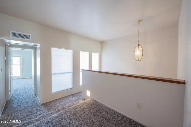 en empty room with windows and ceiling fan