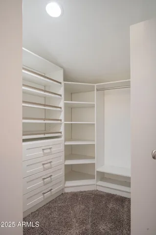 a view of walk in closet with empty racks