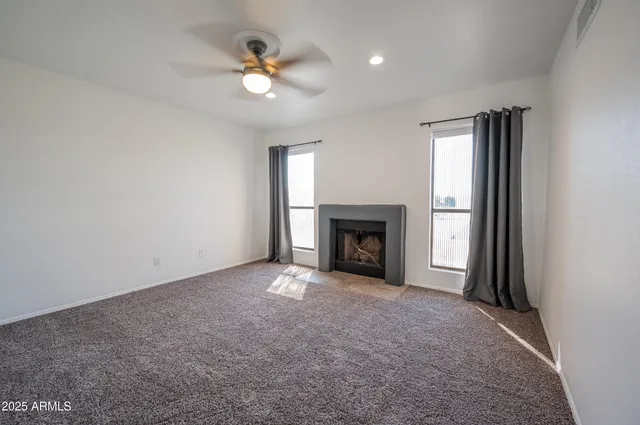 an empty room with fireplace and fan