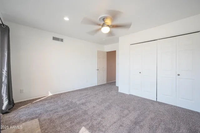 a view of an empty room with a chandelier fan