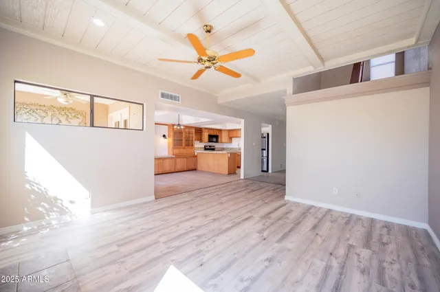 a view of a big room with wooden floor and windows