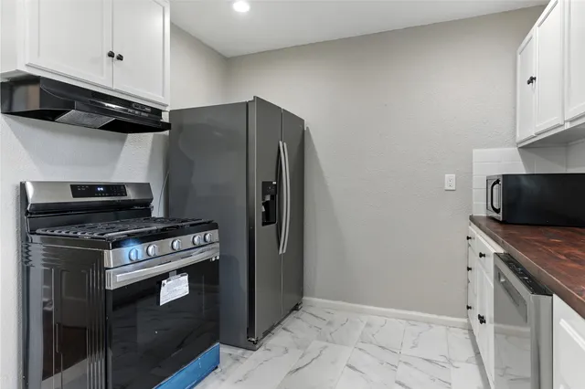 a kitchen with stainless steel appliances granite countertop a stove and a refrigerator