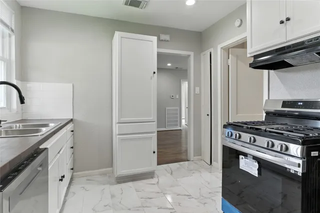 a kitchen with granite countertop a stove and a refrigerator