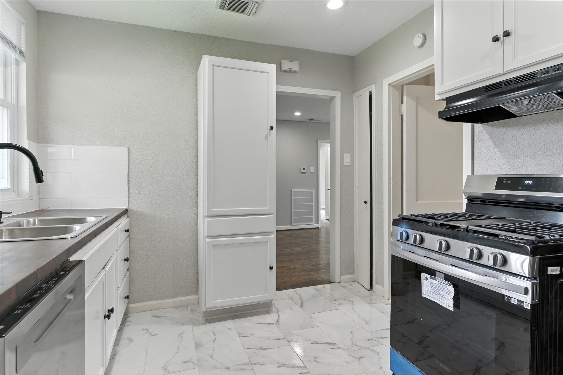 3863 Arbor Street Houston, TX 77004 - Photo 13 of 16 a kitchen with granite countertop a stove and a refrigerator