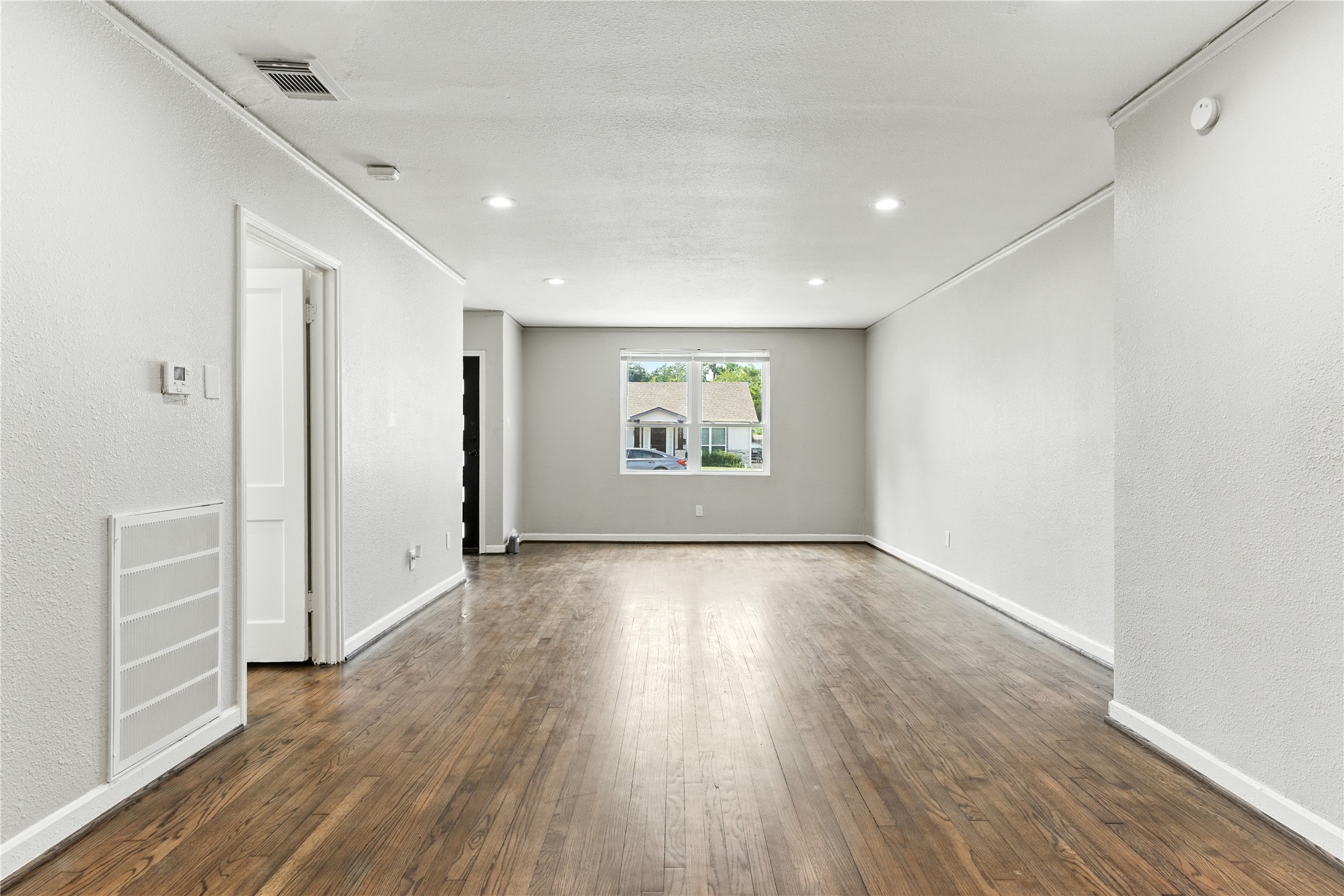 3863 Arbor Street Houston, TX 77004 - Photo 3 of 16 wooden floor in an empty room with a window