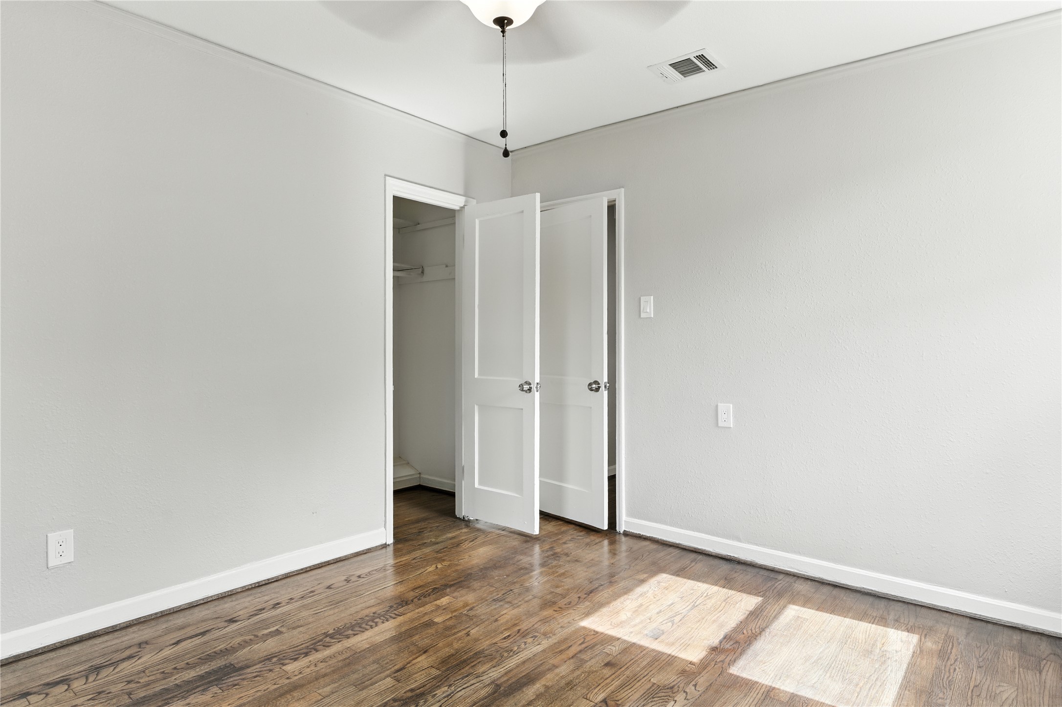 3863 Arbor Street Houston, TX 77004 - Photo 4 of 16 a view of an empty room with wooden floor and a ceiling fan