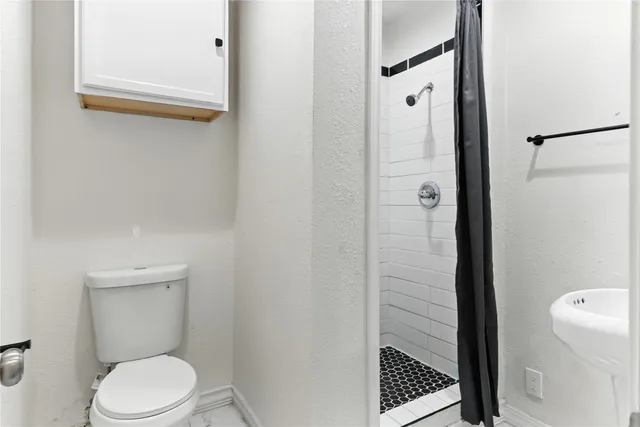 a bathroom with a toilet and a shower