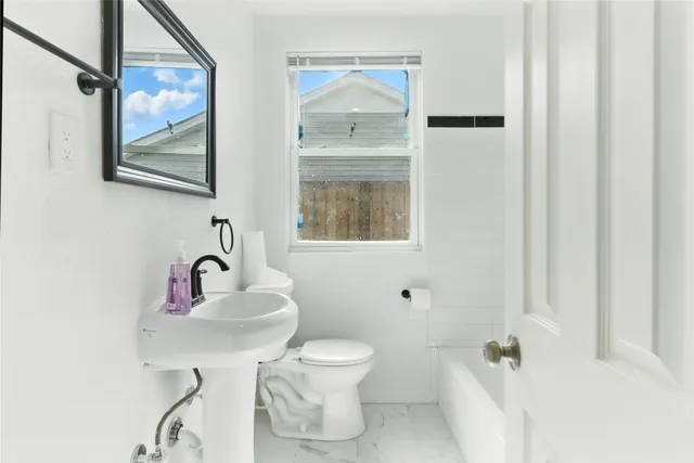 a bathroom with a toilet sink and mirror
