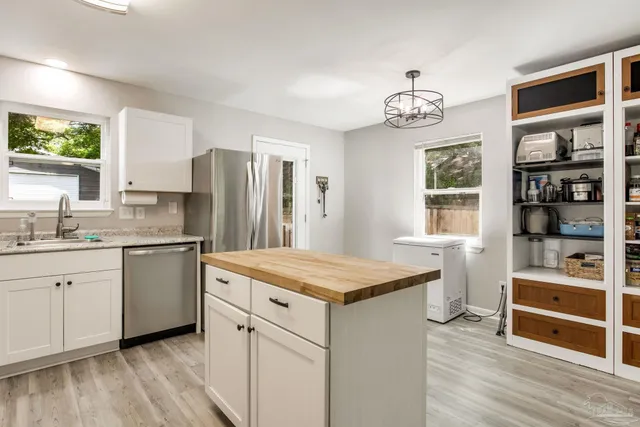 a kitchen with stainless steel appliances a refrigerator and a stove top oven