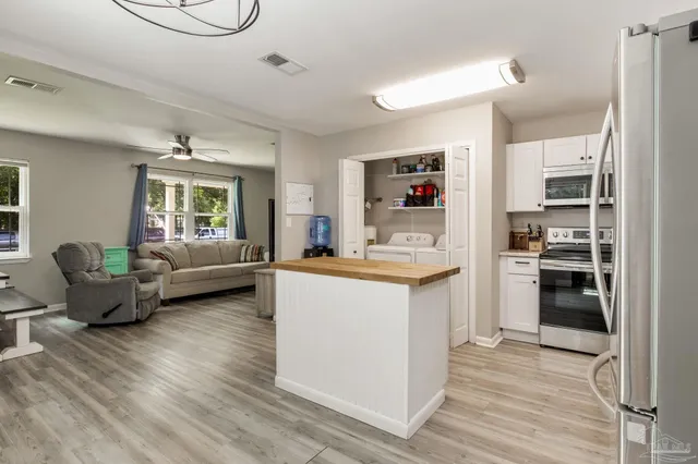 a kitchen with a refrigerator cabinets and wooden floor