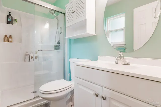 a bathroom with a sink a toilet and shower