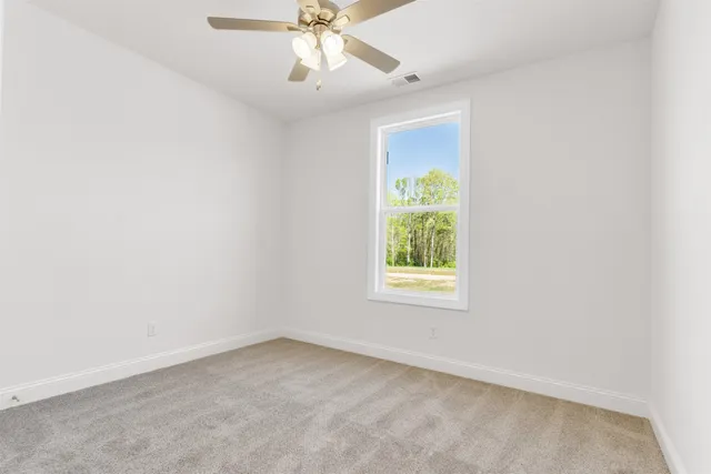 an empty room with a window and a fan