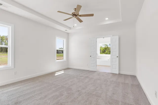 an empty room with a window and a ceiling fan