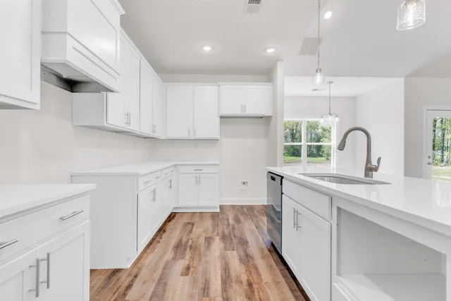 a kitchen with a sink a window and cabinets
